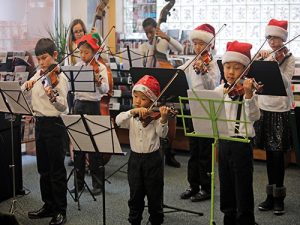 children's orchestra wearing santa hats