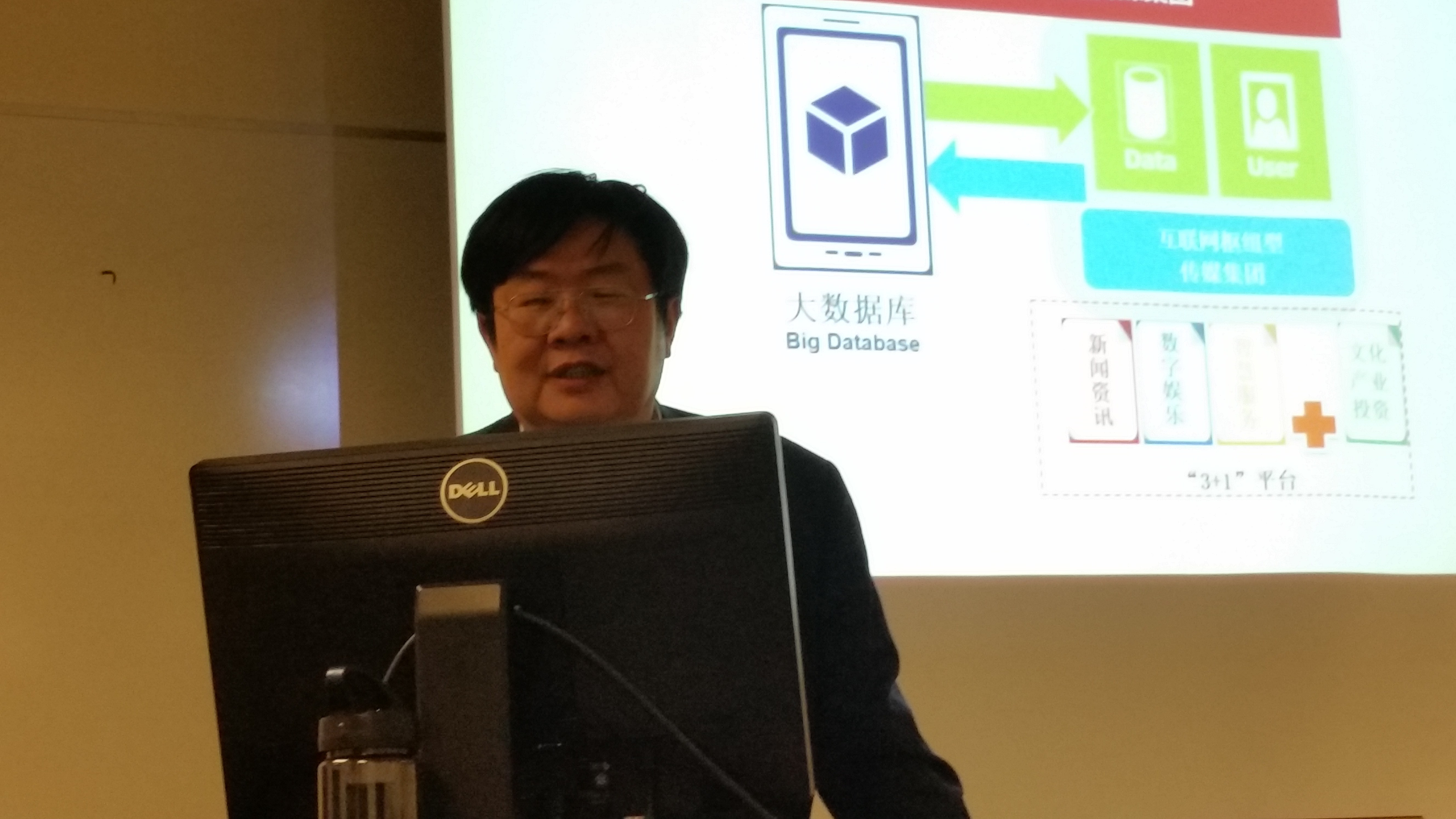 professor at podium in front of powerpoint screen